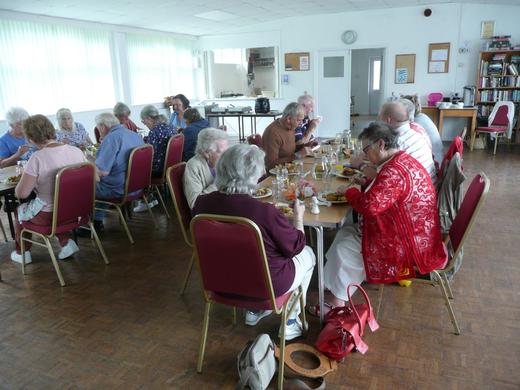 People sitting down to a community lunch with 'Golden Oldies' at Kingstone, Herefordshire